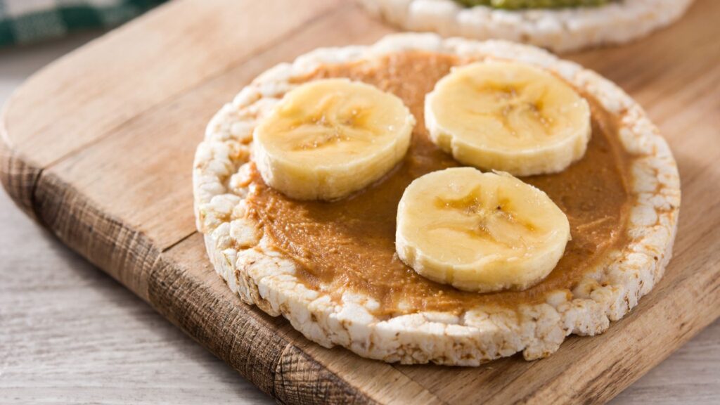 Tostada de maíz untada con mantequilla de maní y plátano en rodajas