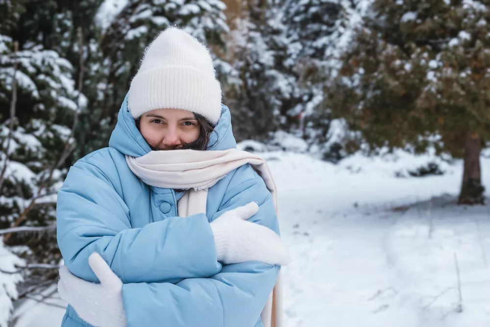 mujer abrigada con gorro y chaqueta al aire libre